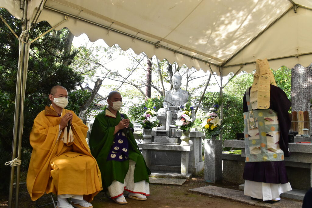 参画寺院の僧侶らとともに、墓前祭を勤める橋本周現師（写真右）